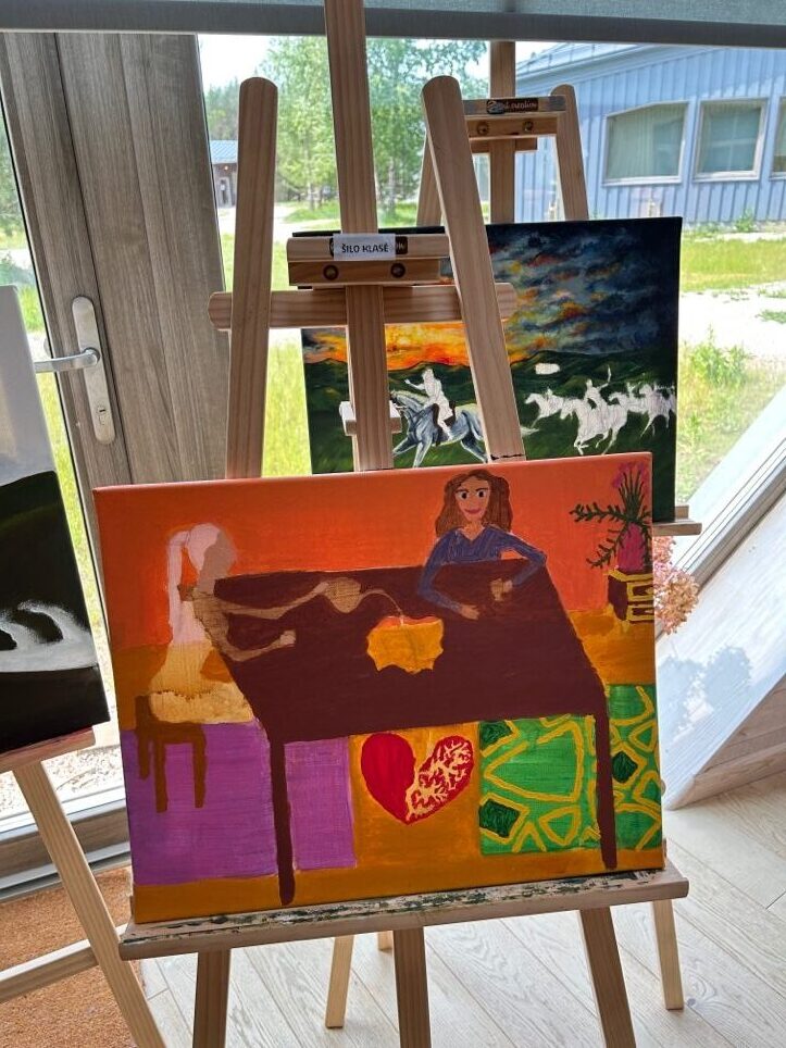 Students' paintings on easels in an art-education studio